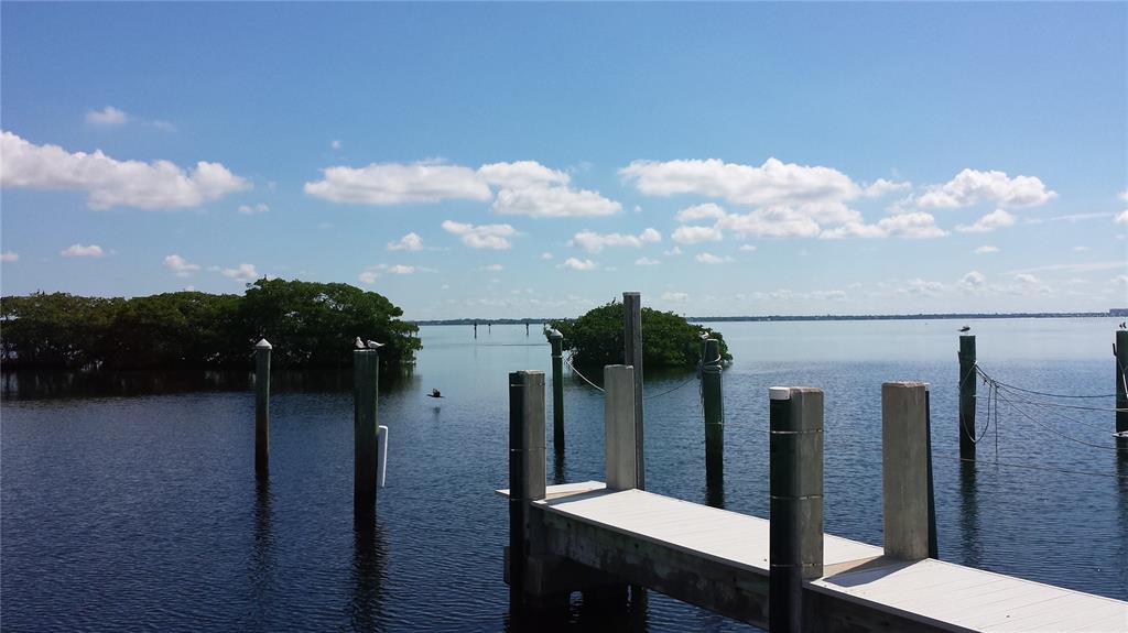 A wooden dock extends into a calm bay with small mangrove islands under a blue sky — 2600 HARBOURSIDE DRIVE UNIT R-13, LONGBOAT KEY, FL