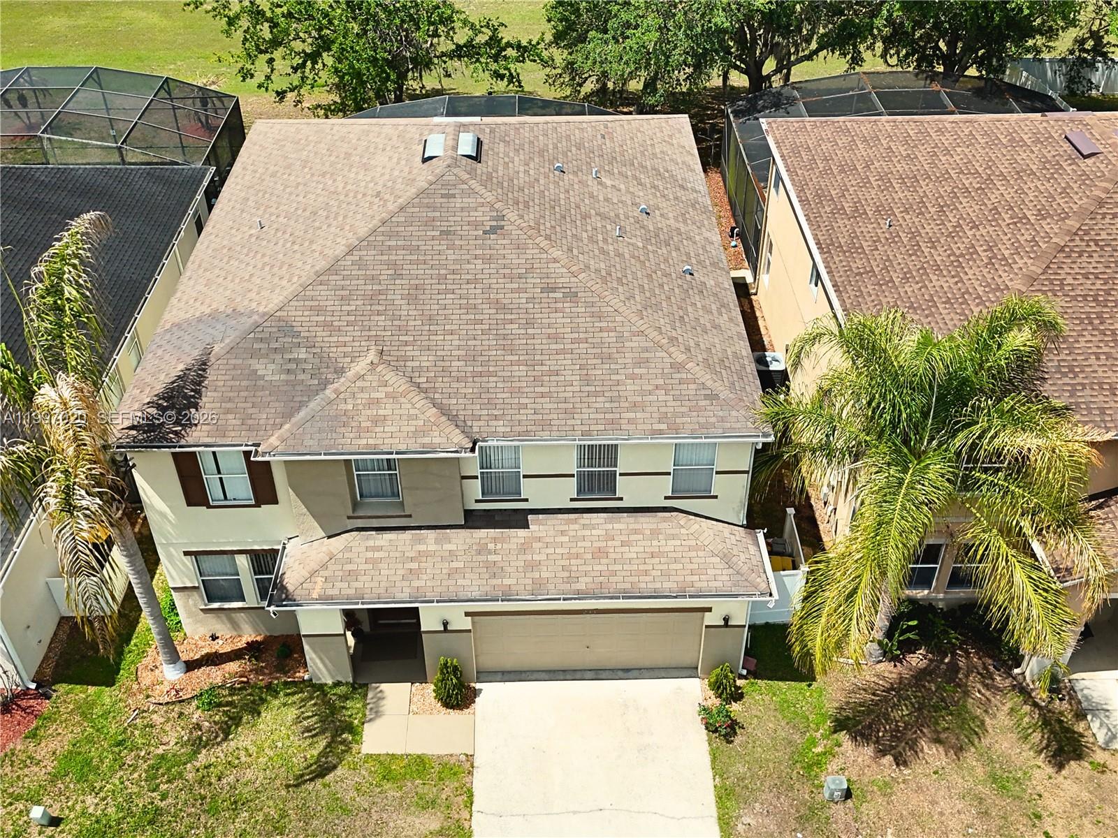 An aerial view shows a two-story house with a brown shingled roof and a garage — 233 Aldridge Ln, Davenport FL 33897, DAVENPORT, FL