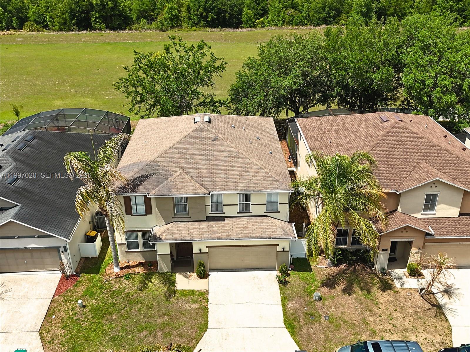 An aerial view shows a two-story suburban house with a brown roof and driveway — 233 Aldridge Ln, Davenport FL 33897, DAVENPORT, FL