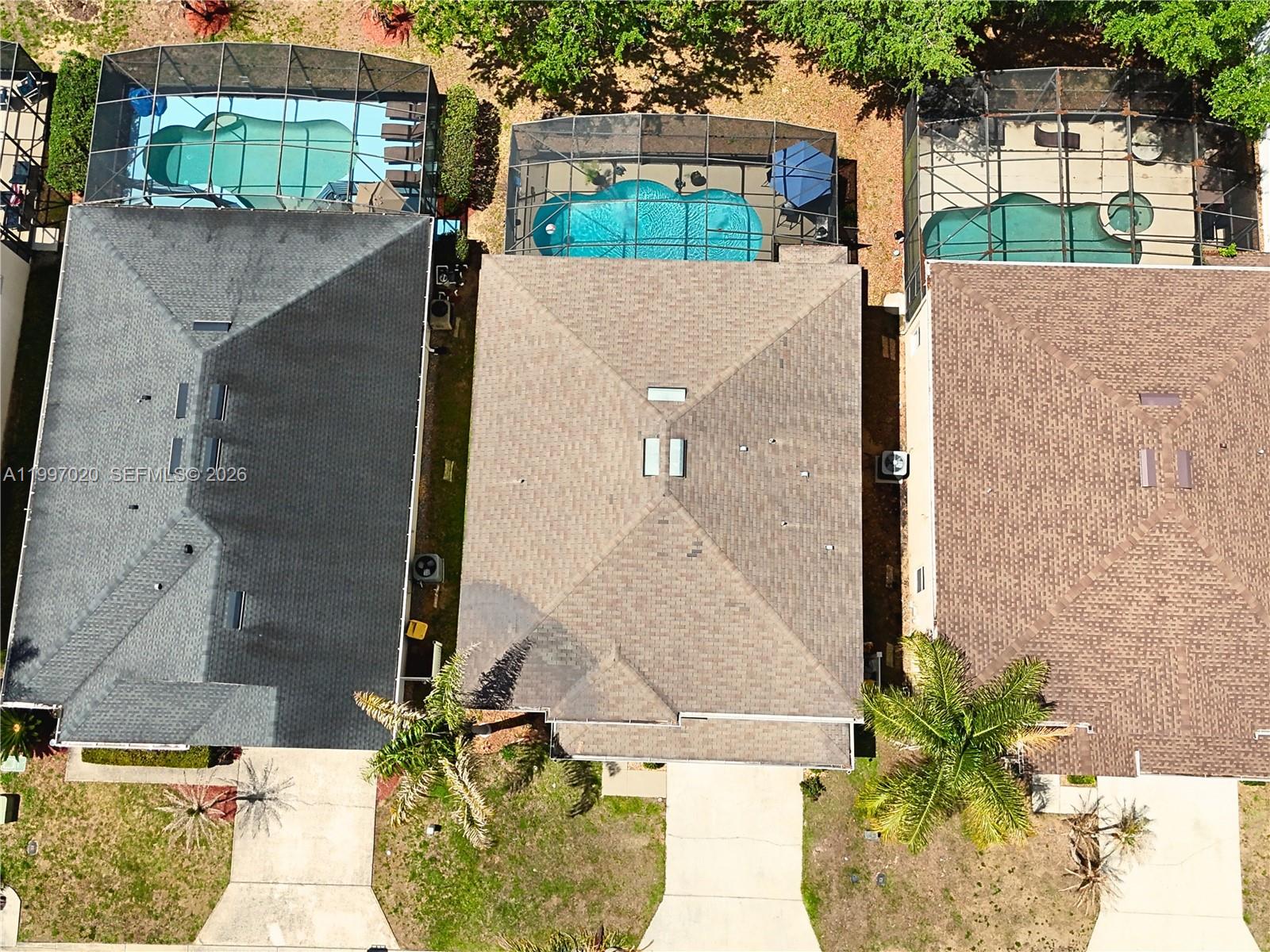 An aerial view shows three houses with screened-in swimming pools and driveways — 233 Aldridge Ln, Davenport FL 33897, DAVENPORT, FL