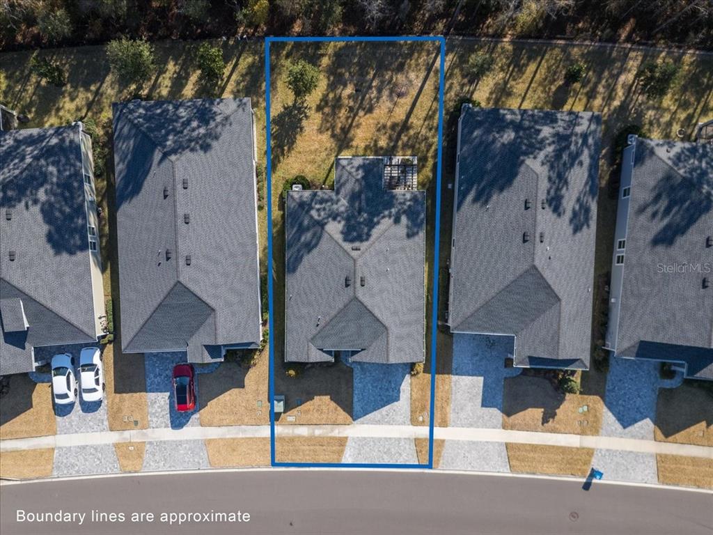 An aerial view shows a single-family home with a backyard outlined in blue — 700 STILLWATER BOULEVARD, ST JOHNS, FL