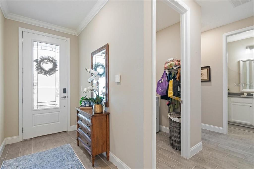 An entryway features a front door, a wooden chest, and a doorway to a laundry room — 700 STILLWATER BOULEVARD, ST JOHNS, FL