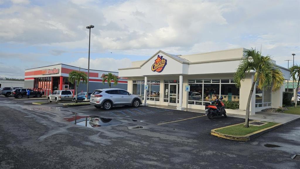 A Church's Chicken restaurant and an AutoZone store stand in a paved parking lot — 100 PR-100 KM 6.8, CABO ROJO, PR