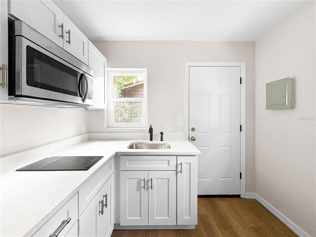 A kitchen features white cabinets, stainless steel appliances, a sink, and light-colored countertops — 306 SW 19TH AVENUE, OCALA, FL