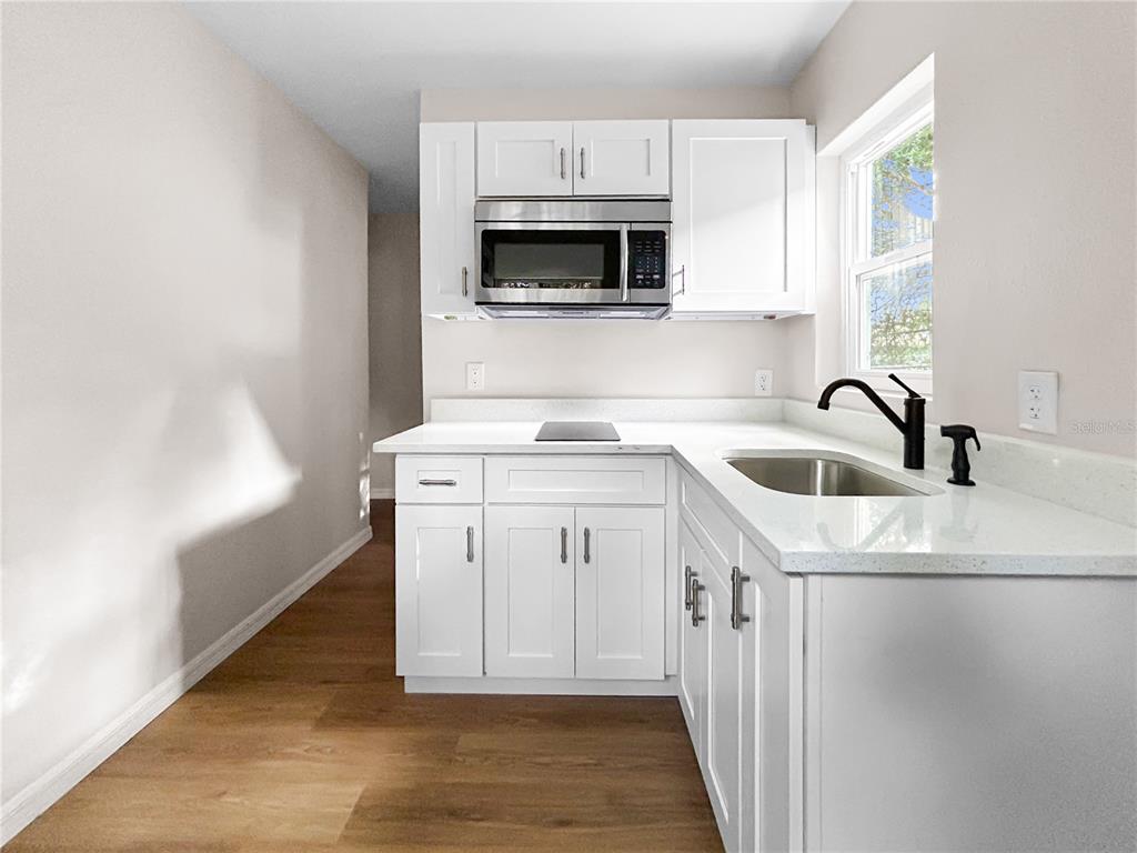 A kitchen features white shaker cabinets, stainless steel appliances, and white countertops — 306 SW 19TH AVENUE, OCALA, FL