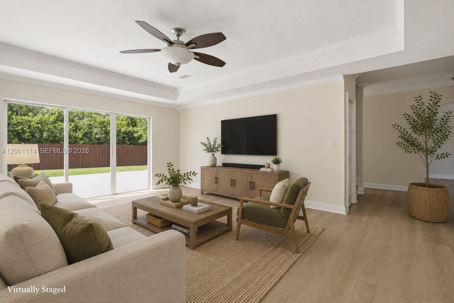 This virtually staged living room features a ceiling fan, light wood flooring, and sliding glass doors — 13474 SW 124th Ave Rd, Miami FL 33186, MIAMI, FL