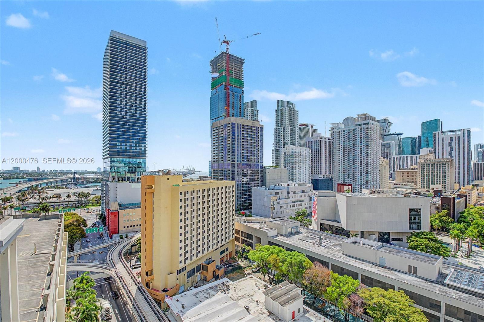 An elevated view of a dense city skyline featuring high-rise buildings and construction cranes — 121 NE 5th ST # 1701, Miami FL 33132, MIAMI, FL