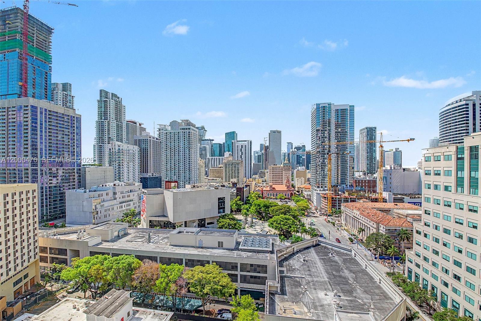 An elevated view of a dense city skyline with numerous skyscrapers and a public park — 121 NE 5th ST # 1701, Miami FL 33132, MIAMI, FL