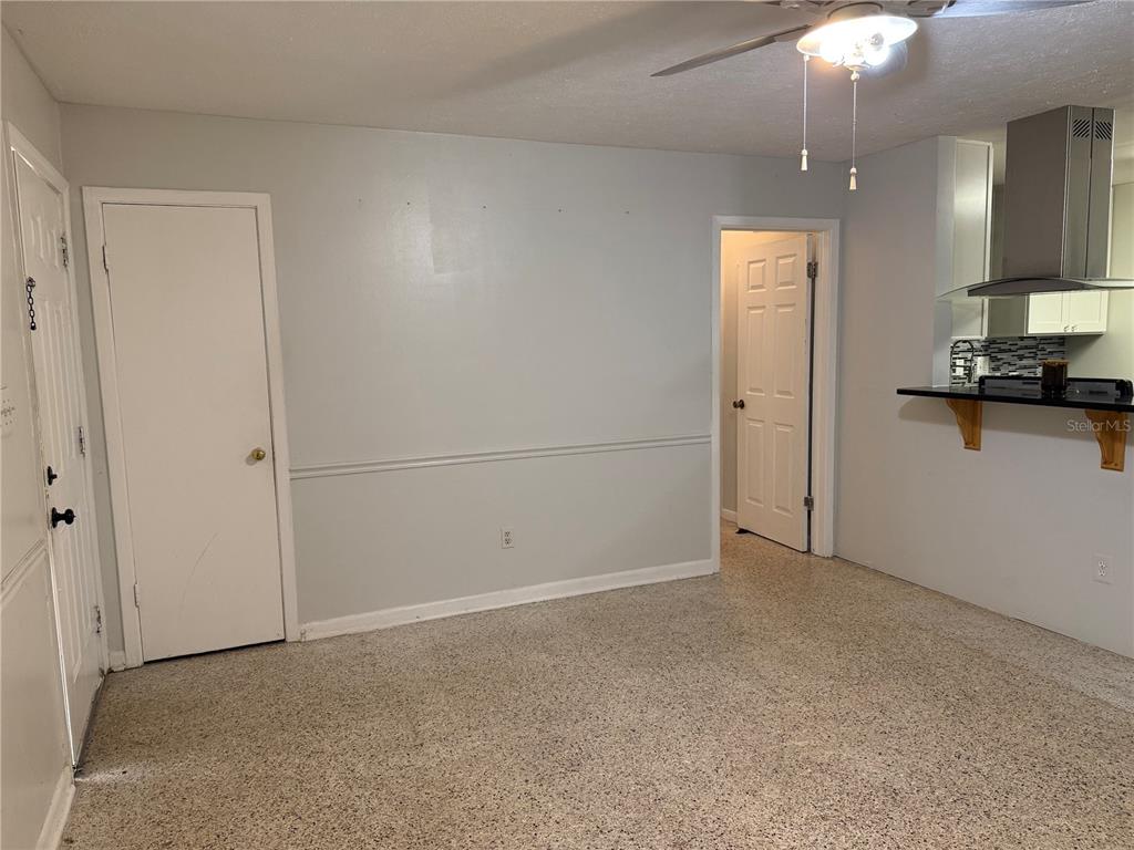 A room with light gray walls, a chair rail, and a speckled floor — 845 EDGEWOOD ROAD, TITUSVILLE, FL