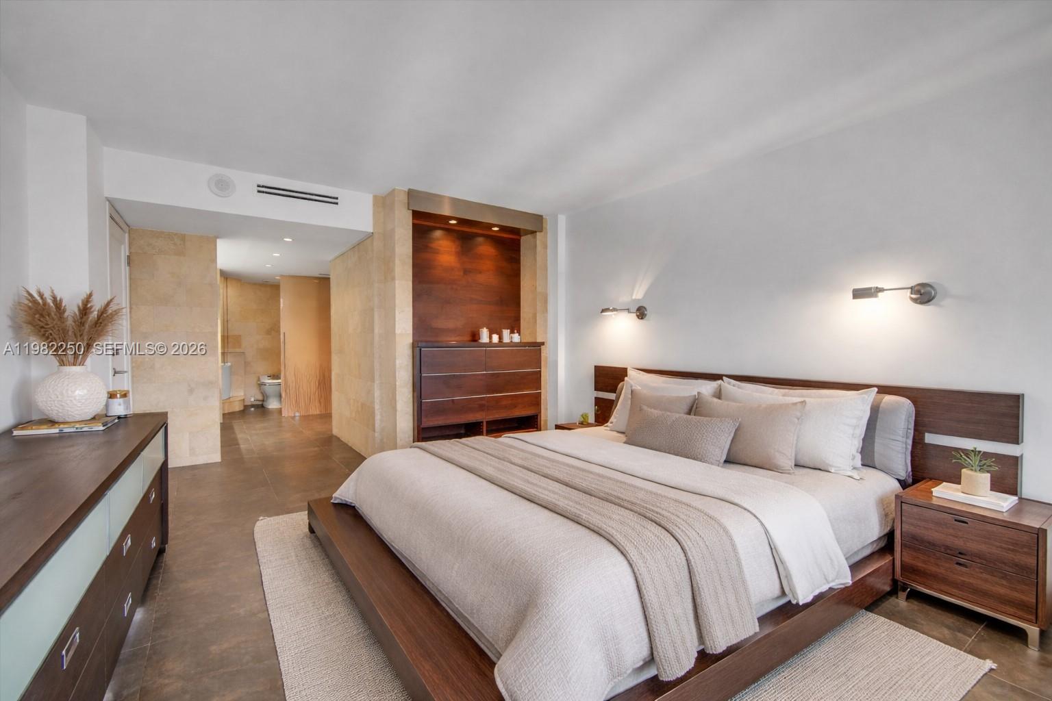 A modern bedroom features a platform bed, dark wood furniture, and an adjacent tiled bathroom — 199 Ocean Lane Dr # 1009, Key Biscayne FL 33149, KEY BISCAYNE, FL