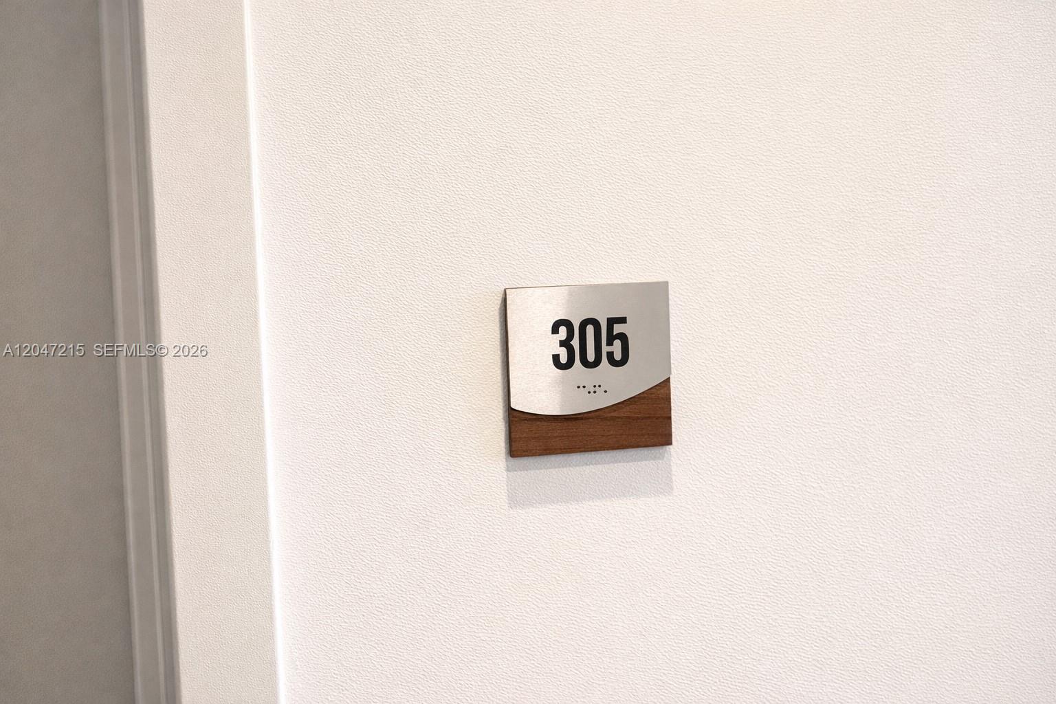 A room number sign labeled 305 with braille is mounted on a white wall — 1950 Fletcher St # 305, Hollywood FL 33020, HOLLYWOOD, FL
