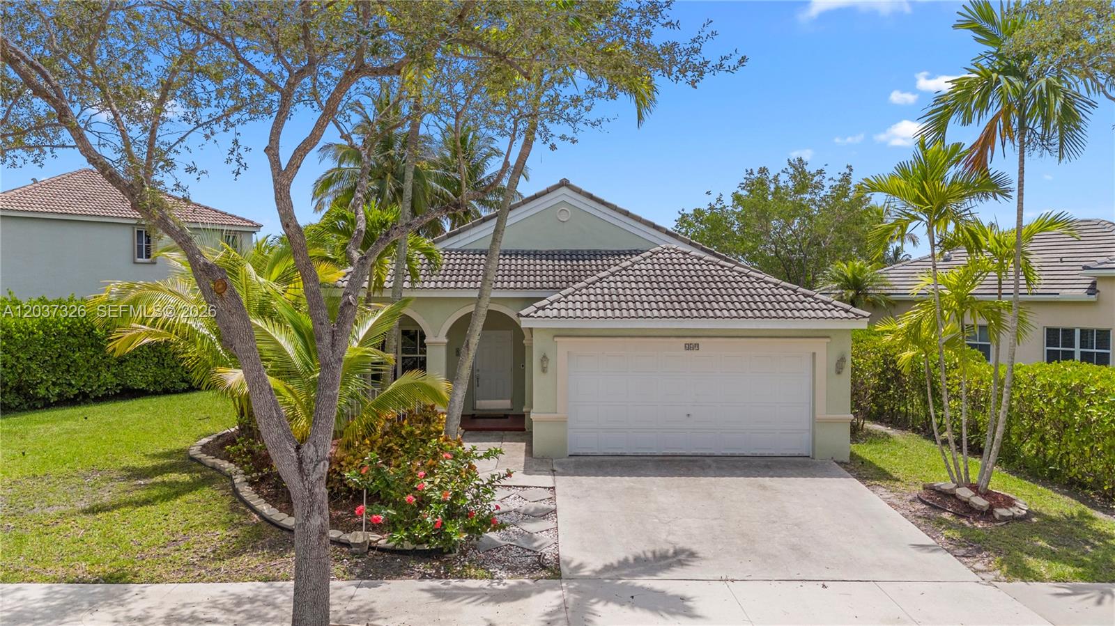 A single-story house with a white garage door, tiled roof, and palm trees in front — 649 Willow Bend Rd, Weston FL 33327, WESTON, FL