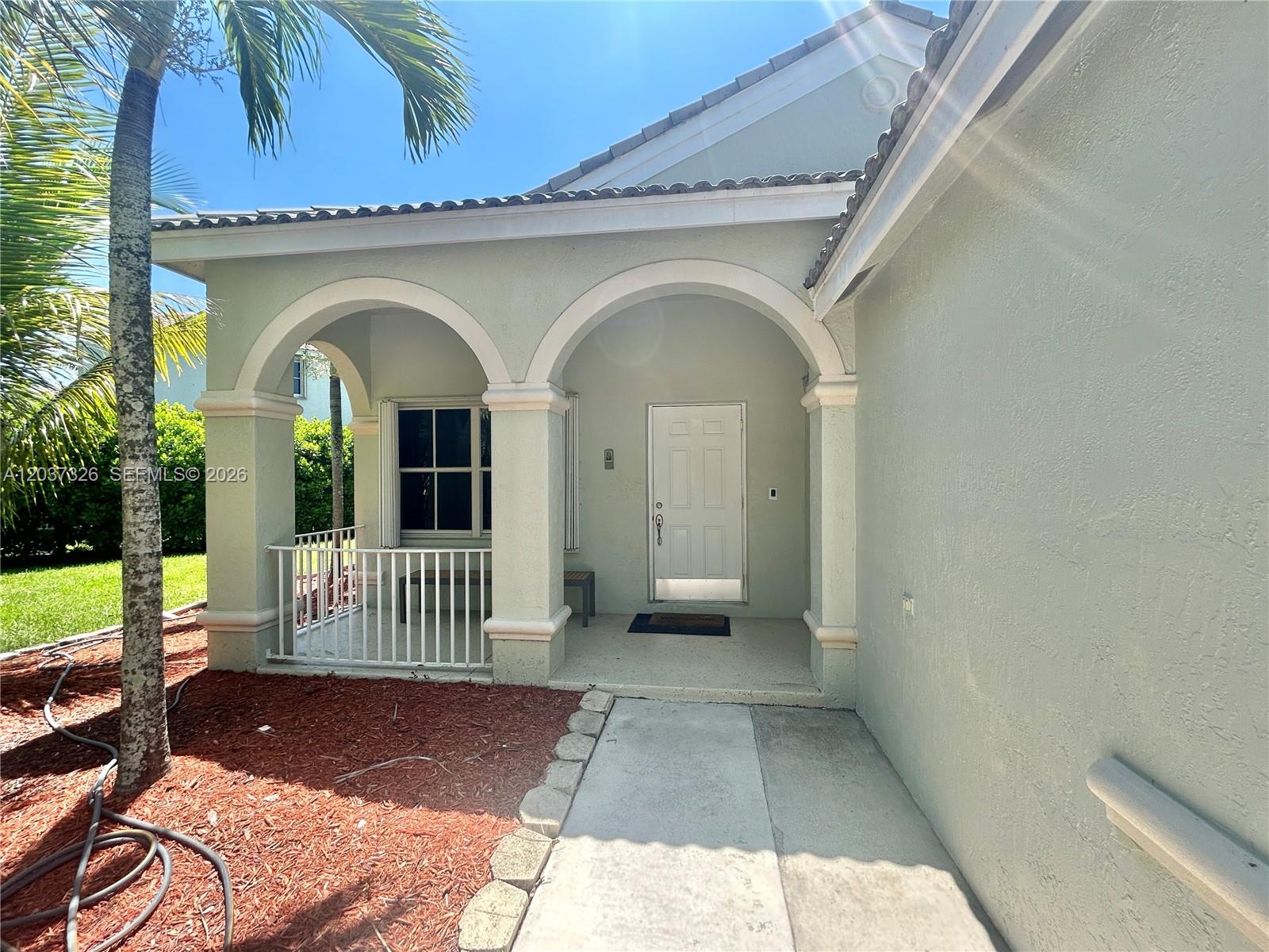 A light green house exterior features a covered entryway with two arched columns — 649 Willow Bend Rd, Weston FL 33327, WESTON, FL