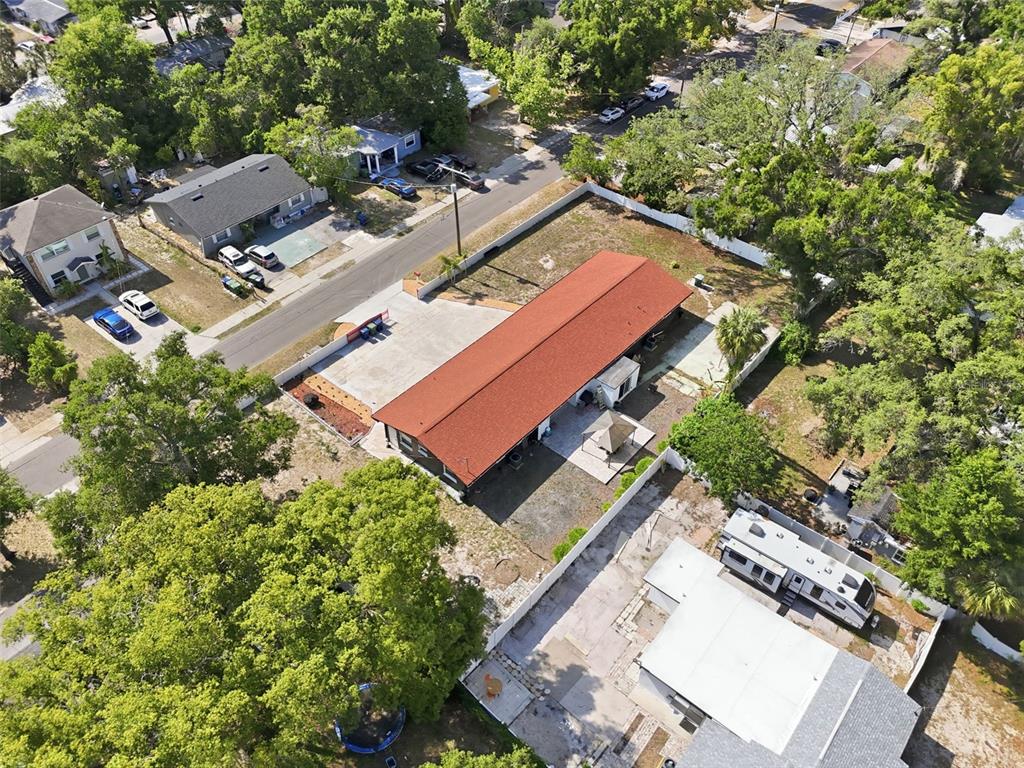 An aerial view shows a long, rectangular building with a red roof and concrete lot — 10107 N ASTER AVENUE, TAMPA, FL