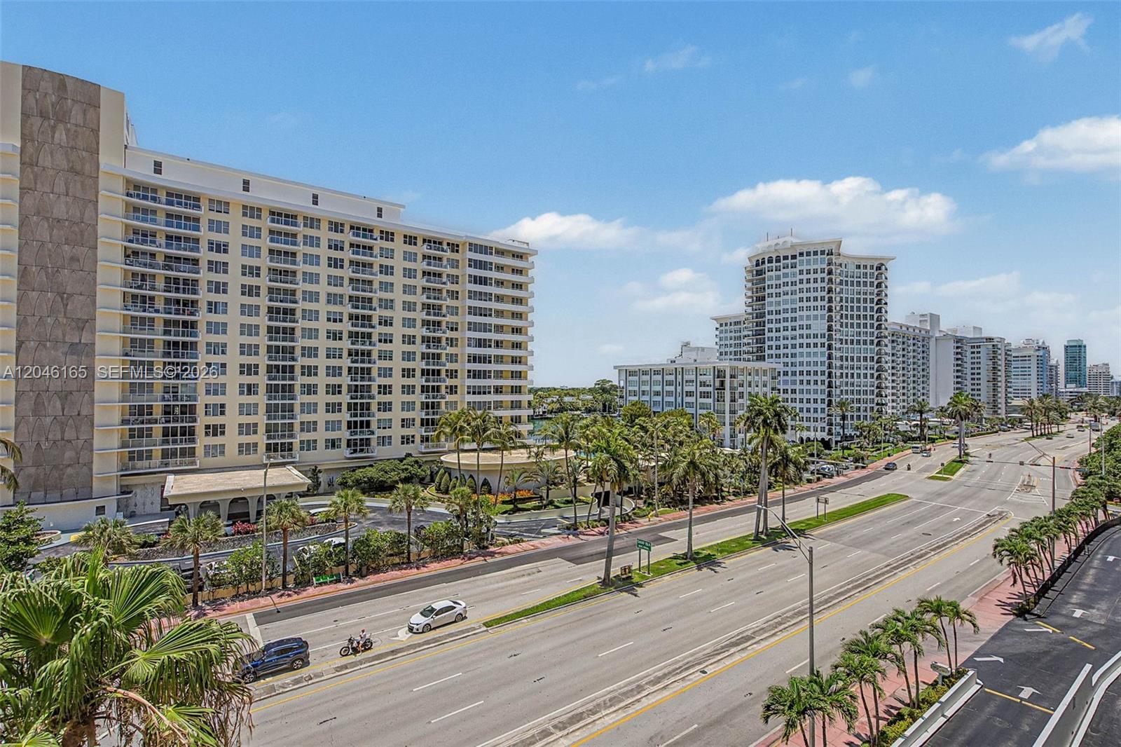 An elevated view shows a multi-lane road running past several tall residential apartment buildings — 5555 Collins Ave # 7B, Miami Beach FL 33140, MIAMI BEACH, FL