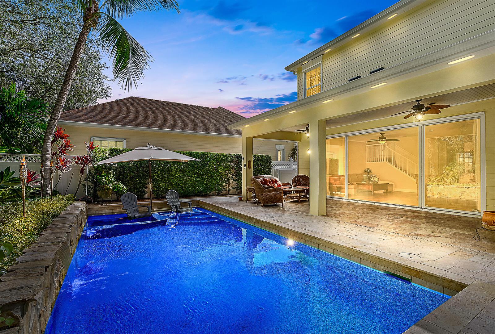 A backyard features a swimming pool with a tanning ledge, patio furniture, and a covered porch — 140 Sweet Bay Circle, Jupiter FL 33458, JUPITER, FL