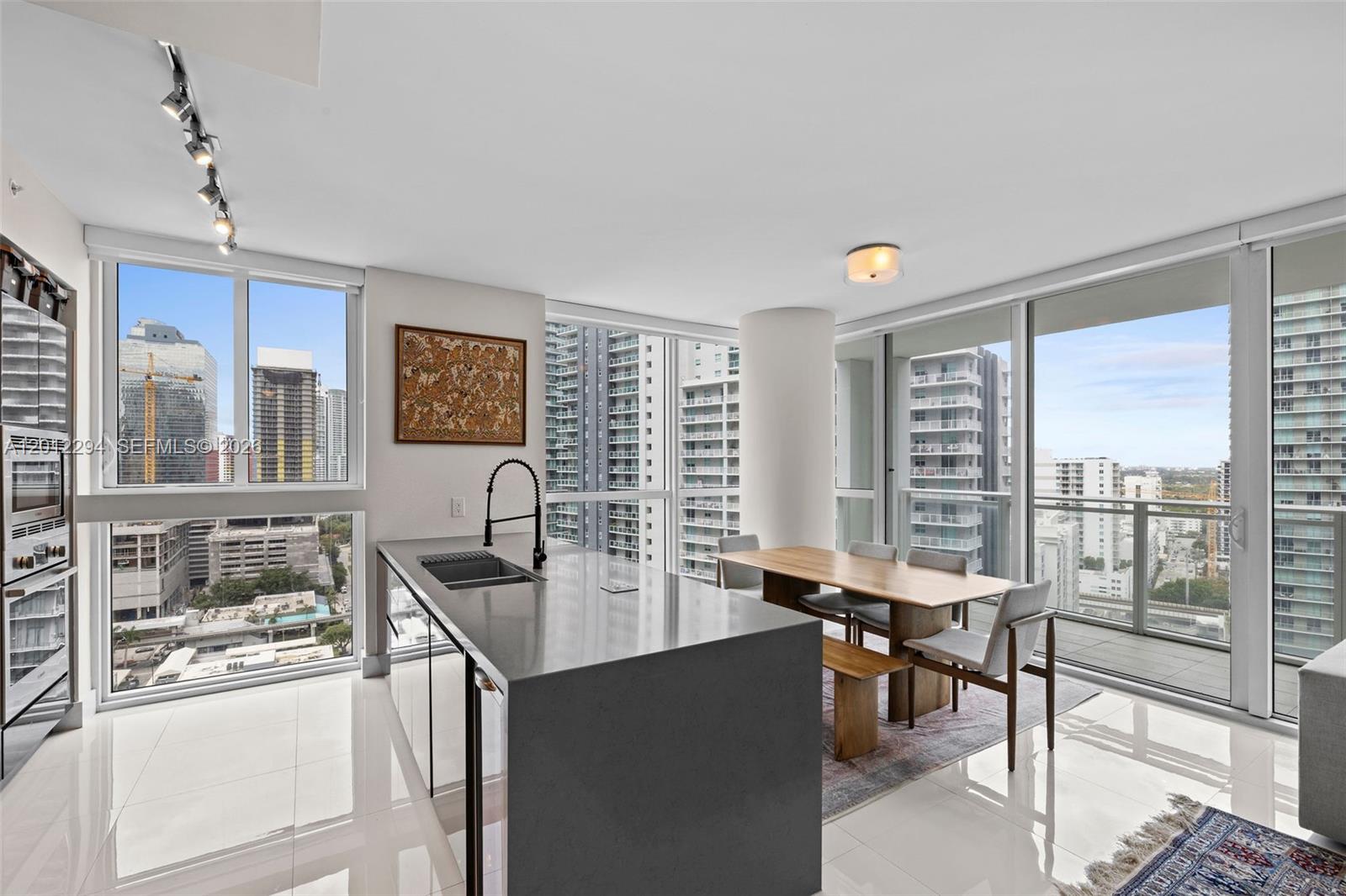 A modern kitchen and dining area with floor-to-ceiling windows overlooking a city skyline — 1080 Brickell Ave # 2001, Miami FL 33131, MIAMI, FL