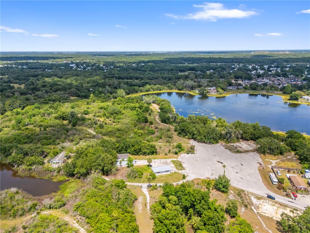 An aerial view shows a rural property with buildings, a large paved area, and lakes — 1100 SKYVIEW BOULEVARD UNIT 1, LAKELAND, FL
