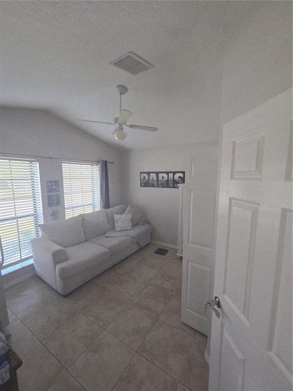 A room with a white sofa, tiled floors, a ceiling fan, and a Paris sign — 1651 RIVER BIRCH AVENUE, OVIEDO, FL