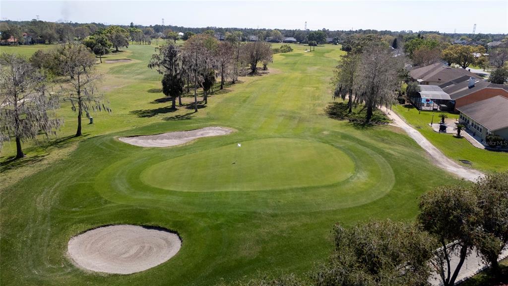An aerial view of a golf course green with two sand bunkers and nearby houses — SABAL STREET, ORLANDO, FL