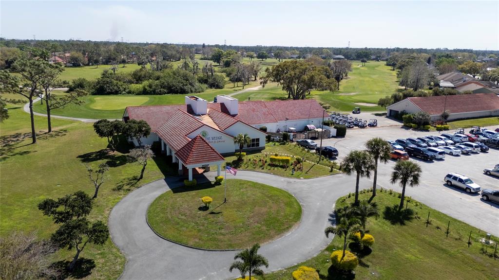An aerial view shows a clubhouse with a red tile roof, circular driveway, and parking lot — SABAL STREET, ORLANDO, FL