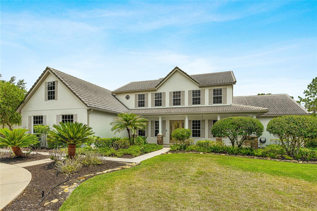 A two-story stucco house with a tiled roof and a landscaped front yard — 22304 DEER POINTE CROSSING, BRADENTON, FL
