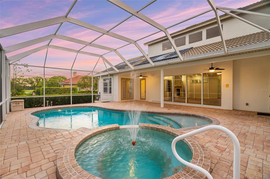 A screened-in patio features a swimming pool, a raised spa with a fountain, and pavers — 22304 DEER POINTE CROSSING, BRADENTON, FL