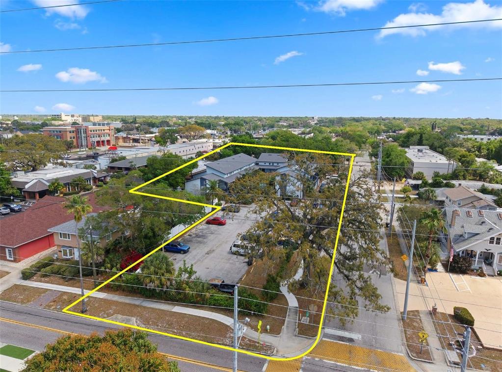 An aerial view shows a commercial building with a parking lot outlined in yellow — 1100 TURNER STREET, CLEARWATER, FL