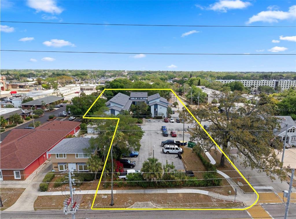 An aerial view shows a commercial building with a parking lot outlined in yellow — 1100 TURNER STREET, CLEARWATER, FL