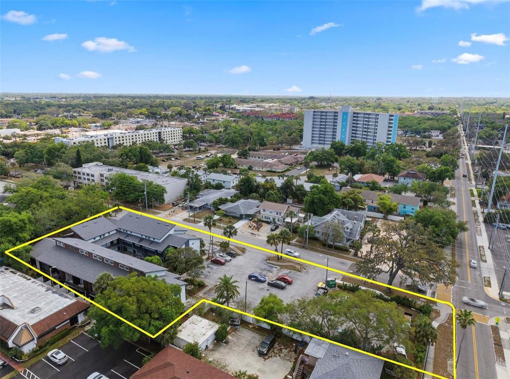 An aerial view shows a multi-story apartment building with a parking lot outlined in yellow — 1100 TURNER STREET, CLEARWATER, FL