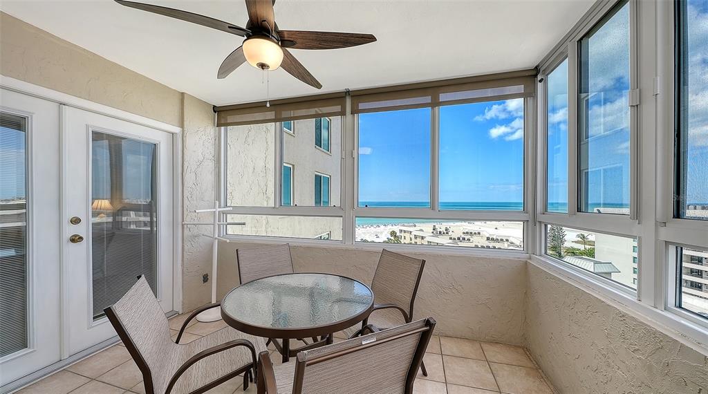 A sunroom with a glass table, four chairs, a ceiling fan, and ocean views — 5920 MIDNIGHT PASS ROAD UNIT 1003, SARASOTA, FL