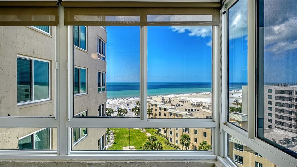 A view of the ocean and beach from a windowed sunroom in a high-rise building — 5920 MIDNIGHT PASS ROAD UNIT 1003, SARASOTA, FL