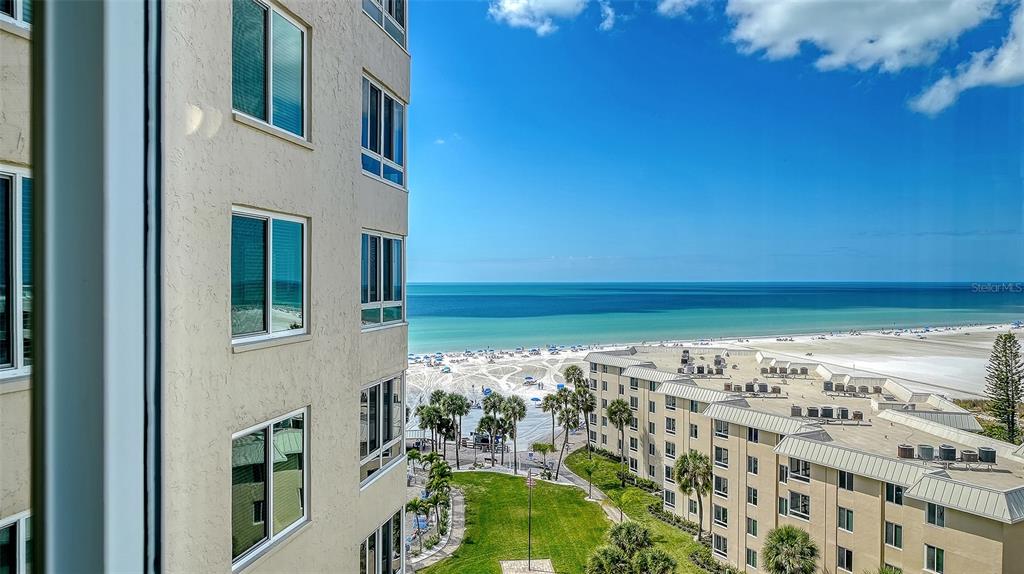 An elevated view of a beach, ocean, and neighboring buildings from a high-rise balcony — 5920 MIDNIGHT PASS ROAD UNIT 1003, SARASOTA, FL