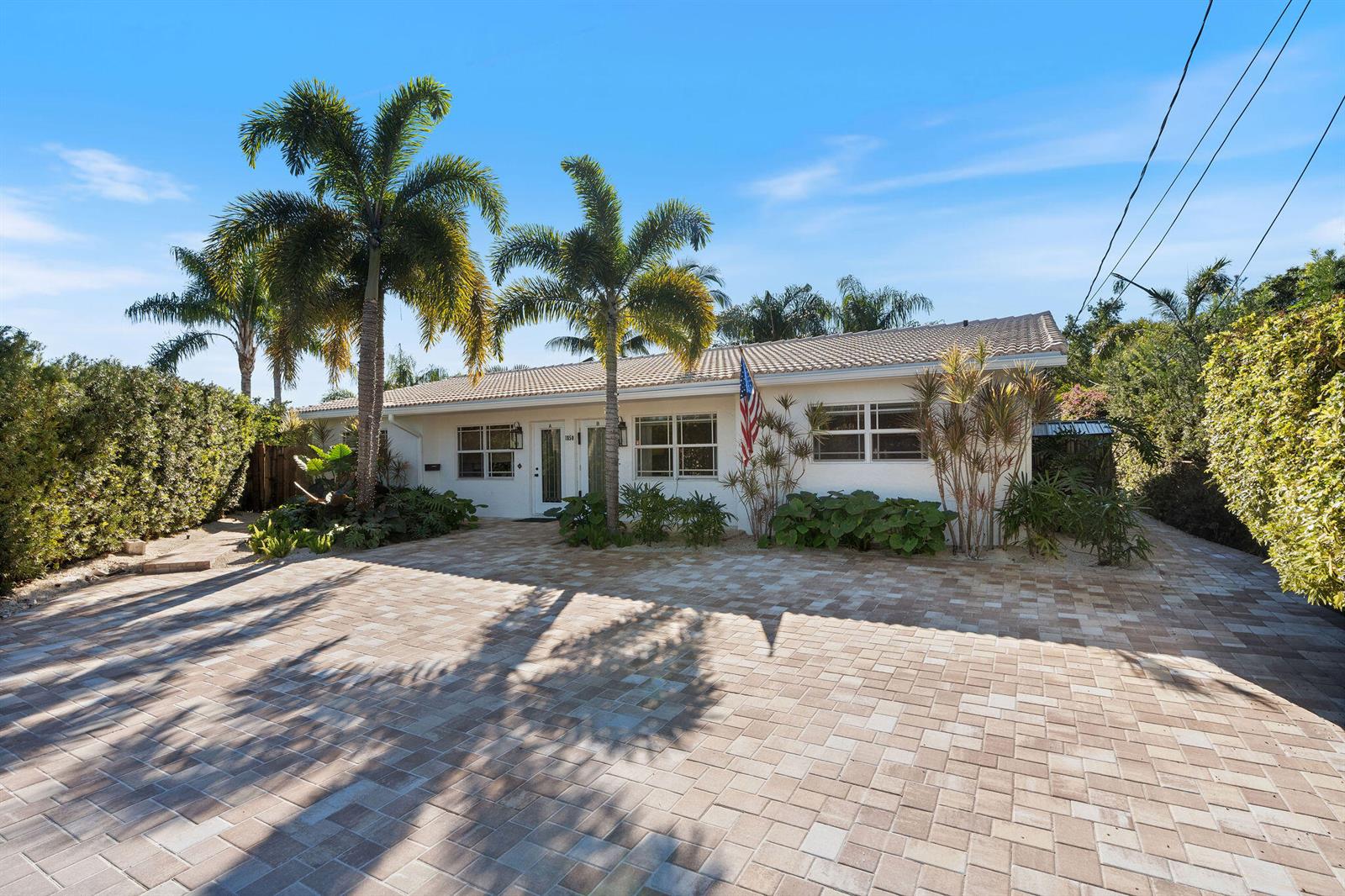 A single-story white house with a paved driveway and palm trees under a blue sky — 1850 SE 7th Street # B, Pompano Beach FL 33060, POMPANO BEACH, FL