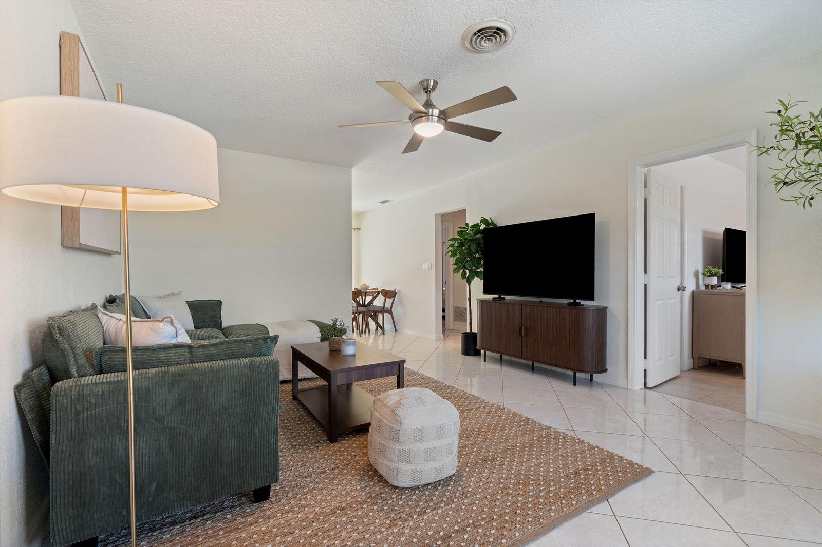 A living room features a green corduroy sofa, a coffee table, and a television console — 1850 SE 7th Street # B, Pompano Beach FL 33060, POMPANO BEACH, FL