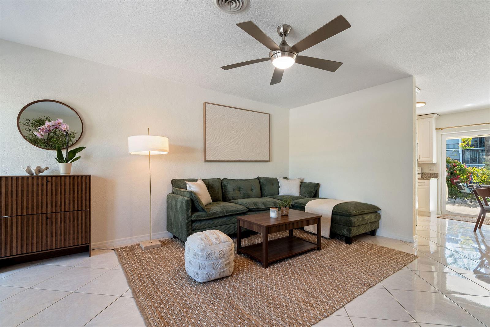 A living room features a green sectional sofa, a jute rug, and a ceiling fan — 1850 SE 7th Street # B, Pompano Beach FL 33060, POMPANO BEACH, FL