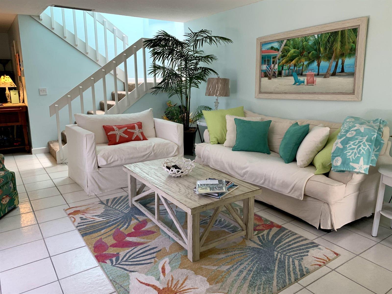 A living room features a white sofa and loveseat, a coffee table, and a patterned rug — 825 Center Street # 21b, Jupiter FL 33458, JUPITER, FL