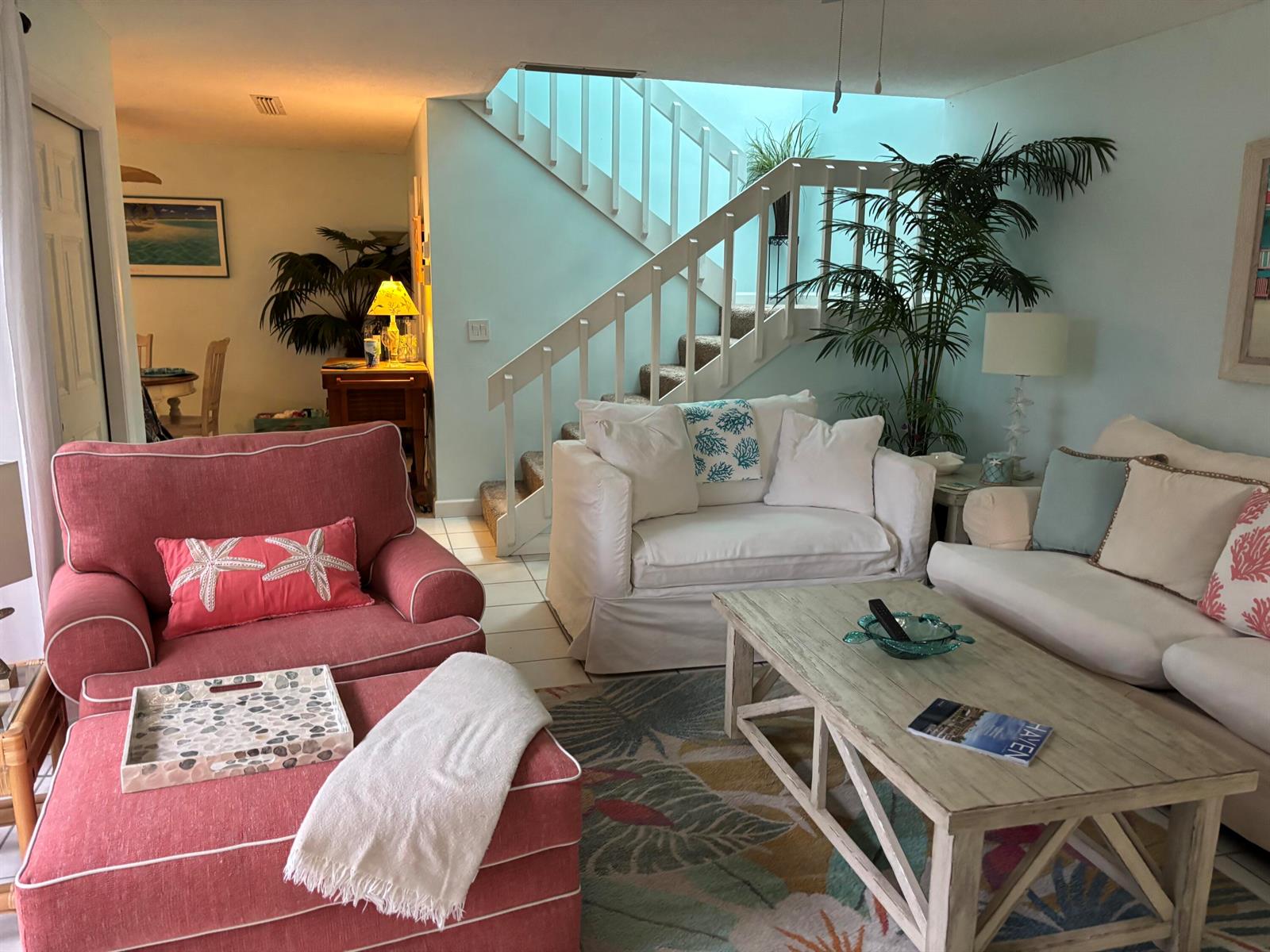 A living room features a pink armchair, white sofa, coffee table, and stairs to the left — 825 Center Street # 21b, Jupiter FL 33458, JUPITER, FL