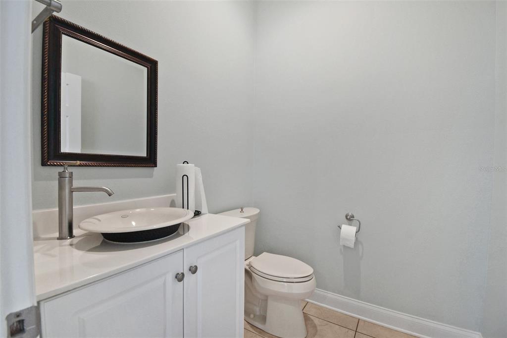 A half bathroom features a white vanity with a vessel sink, a mirror, and a toilet — 2071 DOBBS ROAD, ST AUGUSTINE, FL