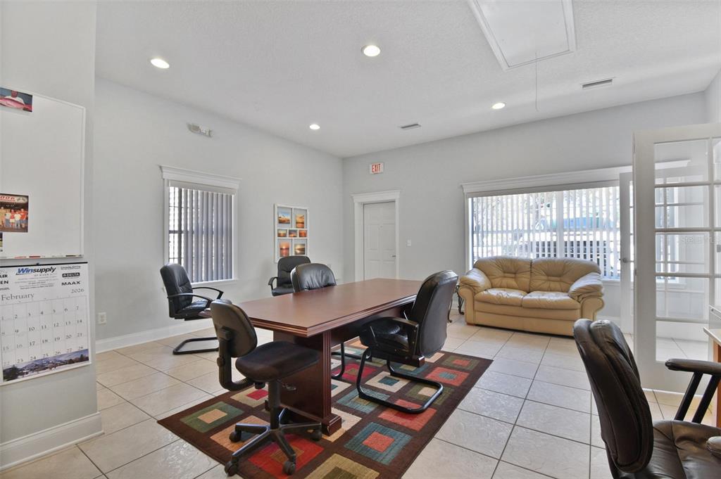An office room features a conference table, chairs, a beige sofa, and tile flooring — 2071 DOBBS ROAD, ST AUGUSTINE, FL