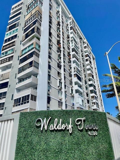 A tall, multi-story residential building stands behind a green hedge featuring the name Waldorf Tower — 4123 ISLA VERDE AVENUE UNIT 16, CAROLINA, PR