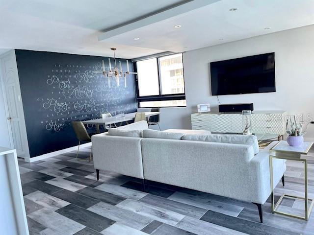 A living room features a large gray sectional sofa, a black accent wall, and wood-look flooring — 4123 ISLA VERDE AVENUE UNIT 16, CAROLINA, PR