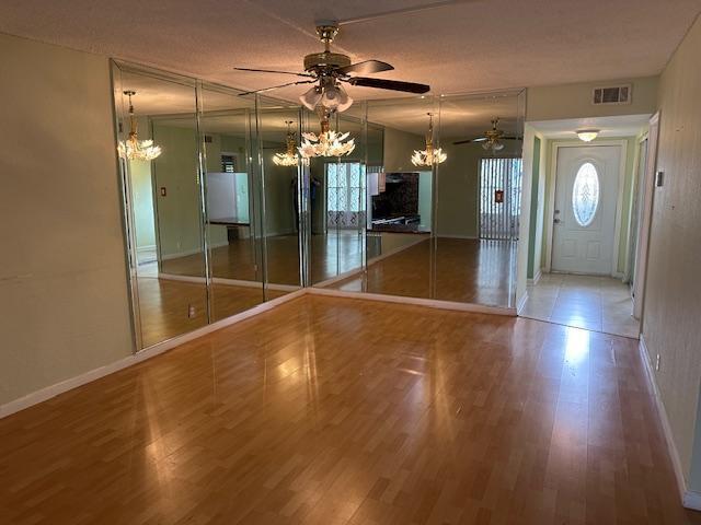An empty room features light wood flooring, a ceiling fan, and a mirrored accent wall — 7300 NW 5th Court # 101, Margate FL 33063, MARGATE, FL