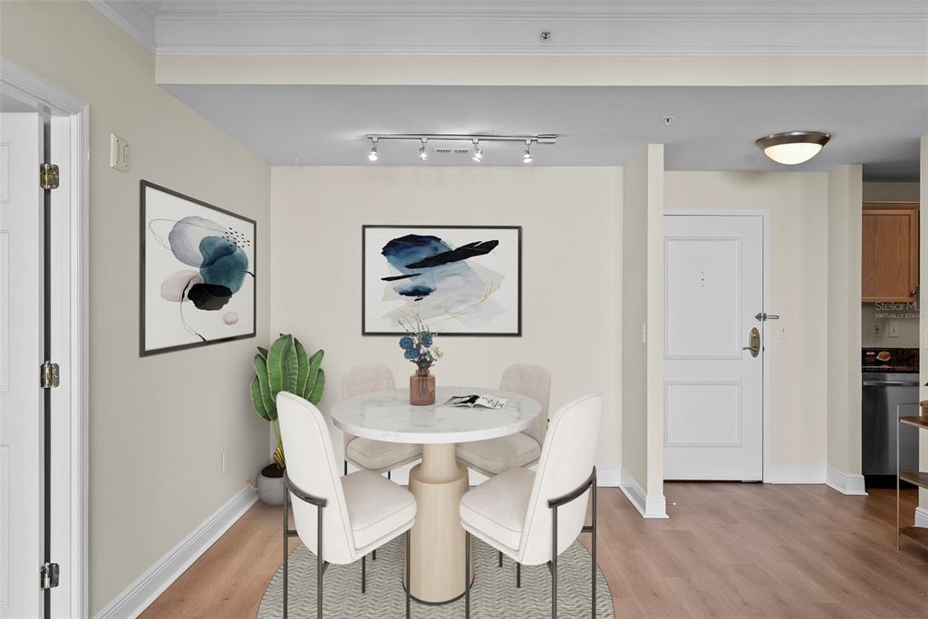 A dining area features a round marble table, four chairs, artwork, and a potted plant — 345 BAYSHORE BOULEVARD UNIT 710, TAMPA, FL