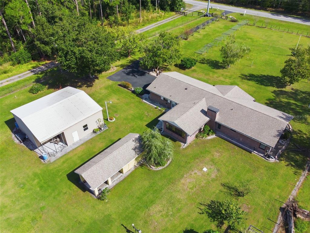 An aerial view shows a house, a detached garage, and a shed on a grassy lot — 9240 MOORE ROAD, LAKELAND, FL