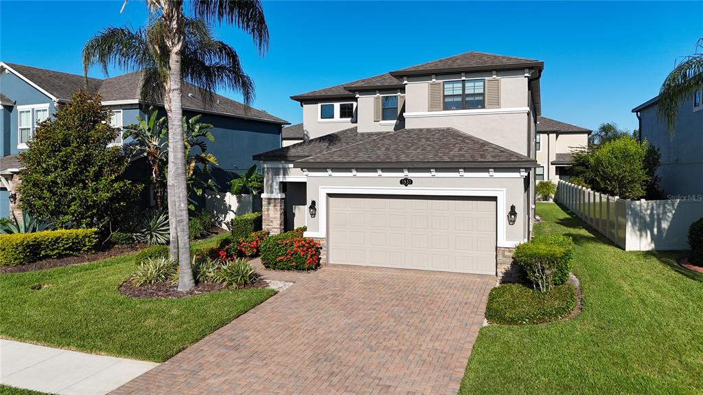 A two-story house with a beige stucco exterior, a paved driveway, and a two-car garage — 1953 NATURE VIEW DRIVE, LUTZ, FL