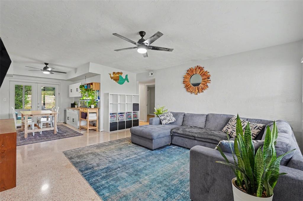 A living room features a gray sectional sofa, a blue area rug, and a dining area — 2270 NOLAN DRIVE, LARGO, FL