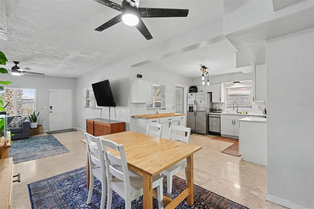 An open-concept living and dining area features a kitchen with white cabinets and stainless appliances — 2270 NOLAN DRIVE, LARGO, FL