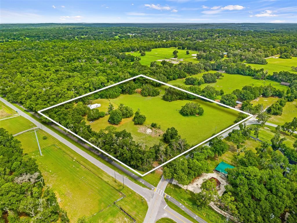 An aerial view shows a large, grassy, rectangular plot of land outlined in white — 9287 WEATHERLY ROAD, BROOKSVILLE, FL