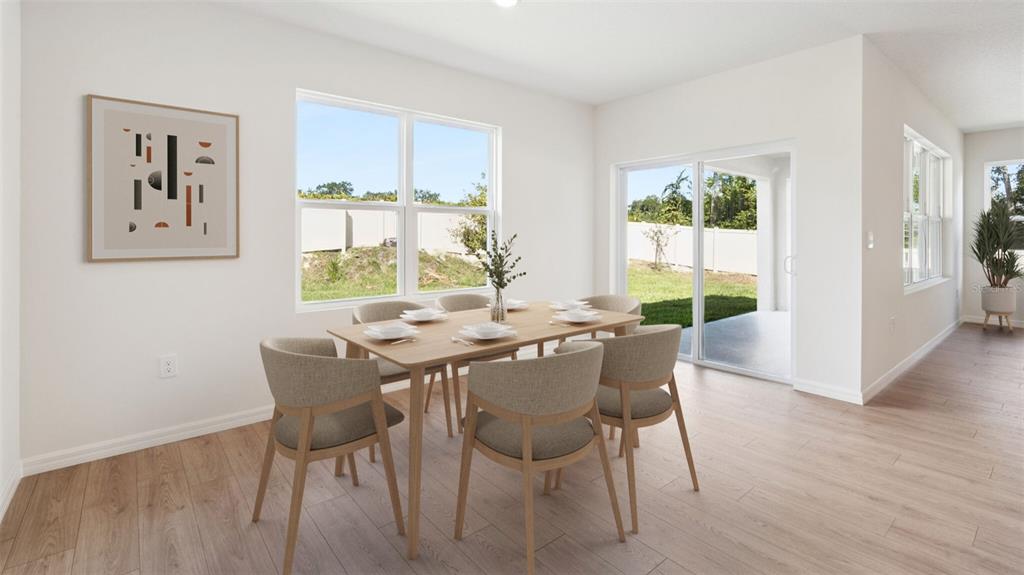 This dining area features light wood flooring, a wooden table with six chairs, and sliding doors — 1348 FOUNTAIN VIEW STREET, ORMOND BEACH, FL